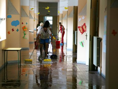 Un operatore del centro polifunzionale rimuove l'acqua all'interno della scuola San Modesto